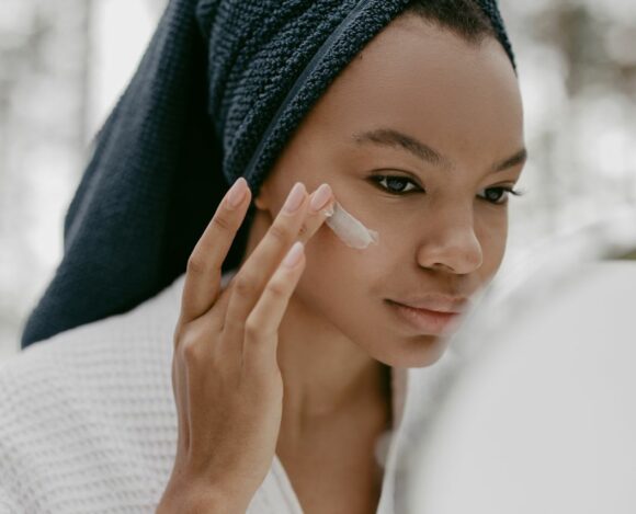 Black woman applying a Retinol cream