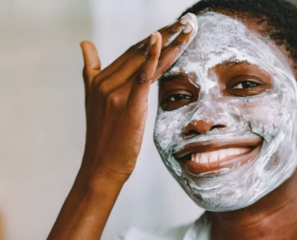 healing-skin-after-hydroquinone-bleaching Black woman with facial skin bleaching damage using a clay mask to soothe and heal her skin