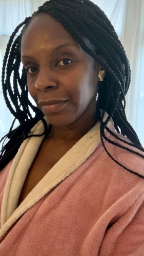 Black woman wearing long box braids as a protective style for natural hair